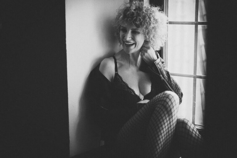 Frau mit Locken sitzt am Fenster, Schwarzweiß